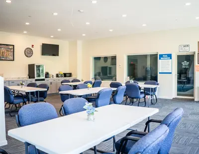 a room with tables and chairs and a kitchen at Allen Lake Resort Richfield Springs Cooperstown in Richfield Springs