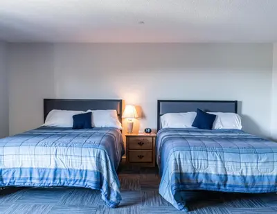 two beds sitting next to each other in a bedroom at Allen Lake Resort Richfield Springs Cooperstown in Richfield Springs