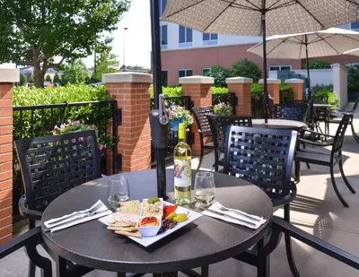 a table with a plate of food and a bottle of wine at Hyatt Place Garden City in Garden City