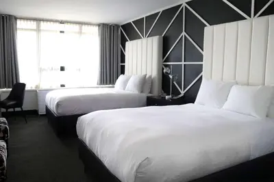 a hotel room with two beds and a window at Hotel NoMa, Trademark Collection by Wyndham in New Rochelle