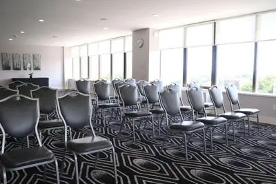 a row of chairs in a room with windows at Hotel NoMa, Trademark Collection by Wyndham in New Rochelle