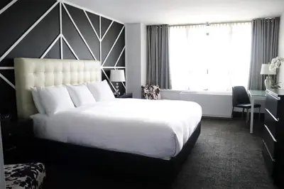 a hotel room with a large white bed and a window at Hotel NoMa, Trademark Collection by Wyndham in New Rochelle