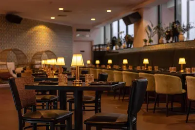 a restaurant with tables and chairs and a bar at Hotel NoMa, Trademark Collection by Wyndham in New Rochelle