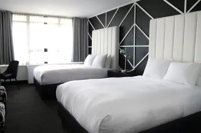 a hotel room with two beds and a window at Hotel NoMa, Trademark Collection by Wyndham in New Rochelle