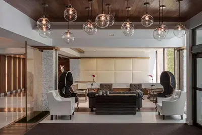 a lobby with a table and chairs and lights at Hotel NoMa, Trademark Collection by Wyndham in New Rochelle