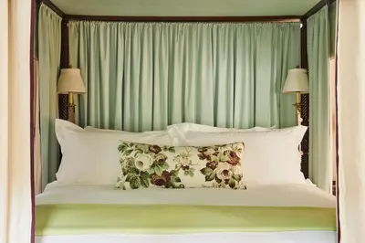 a bed with a green headboard and pillows at The Mayflower Inn & Spa, Auberge Collection in Washington