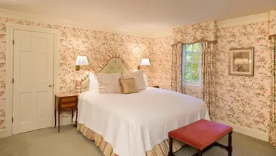 a bedroom with a bed with pink floral wallpaper at The Mayflower Inn & Spa, Auberge Collection in Washington