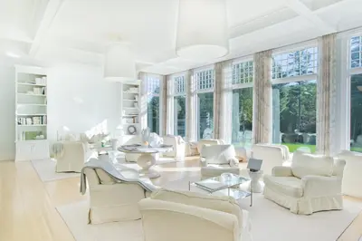 a living room with white furniture and large windows at The Mayflower Inn & Spa, Auberge Collection in Washington