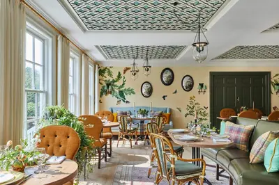 a restaurant with tables and chairs and windows at The Mayflower Inn & Spa, Auberge Collection in Washington