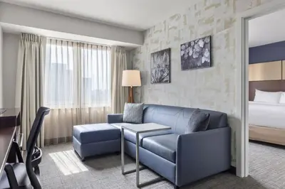 a hotel room with a couch and a bed at Residence Inn by Marriott The Bronx at Metro Center Atrium in Bronx
