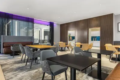 a restaurant with tables and chairs and a couch at Residence Inn by Marriott The Bronx at Metro Center Atrium in Bronx
