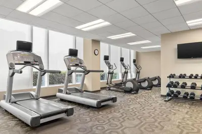 a fitness room with cardio machines and a flat screen tv at Residence Inn by Marriott The Bronx at Metro Center Atrium in Bronx