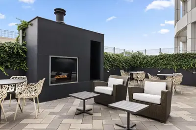a patio with chairs and tables and a fireplace at Residence Inn by Marriott The Bronx at Metro Center Atrium in Bronx