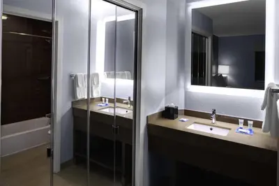 a bathroom with two sinks and a mirror and a tub at Hyatt House Morristown in Morristown