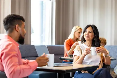 a group of people sitting at a table with cups of coffee at Hyatt House Morristown in Morristown
