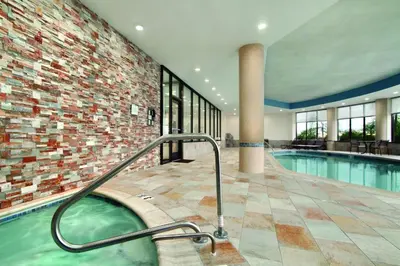a swimming pool with a hot tub in a building at Hyatt House Hartford North/Windsor in Windsor