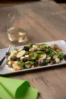a plate of salad on a table with a glass of wine at Hyatt House Hartford North/Windsor in Windsor