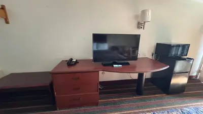 a desk with a television on top of it in a room at Rodeway Inn Dunmore in Dunmore