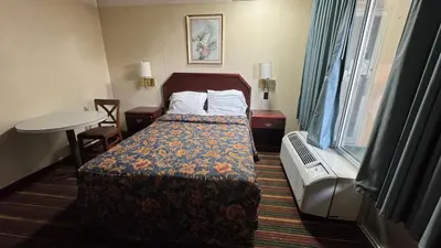 a hotel room with a bed and a table at Rodeway Inn Dunmore in Dunmore