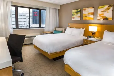 a hotel room with two beds and a window at Delta Hotels by Marriott Utica in Utica