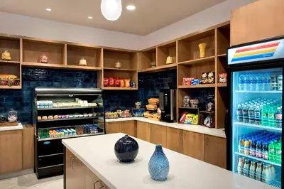 a kitchen with a refrigerator and a counter with vases on it at Delta Hotels by Marriott Utica in Utica