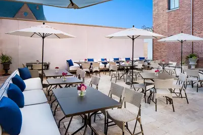 a patio with tables and chairs and umbrellas at The Adelphi Hotel in Saratoga Springs