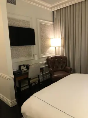 a hotel room with a bed and a desk and a chair at The Adelphi Hotel in Saratoga Springs