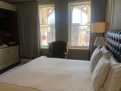 a bedroom with a large white bed and a chair at The Adelphi Hotel in Saratoga Springs