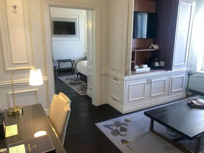 a living room with a table and a dining room at The Adelphi Hotel in Saratoga Springs