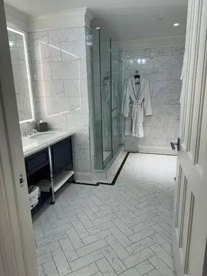 a bathroom with a shower and a robe on a rack at The Adelphi Hotel in Saratoga Springs