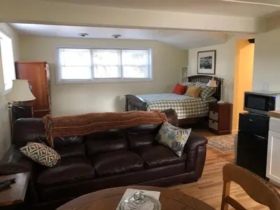 a living room with a couch and a bed at Cozy Garden Apartment Along the Shoreline in Guilford