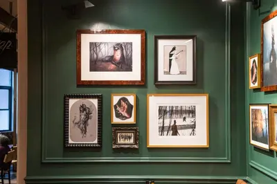 a wall with framed pictures on a green wall at Pod 39 in New York