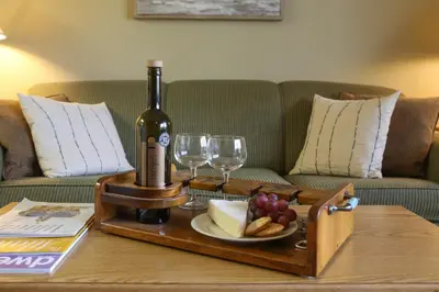 a table with a bottle of wine and wine glasses at Silver Birches Resort in Hawley