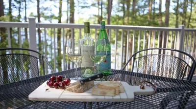 a table with a bottle of wine and cheese and grapes at Silver Birches Resort in Hawley