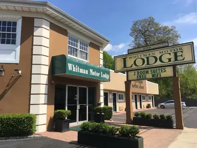 a building with a sign for alderman motel at Whitman Motor Lodge in Huntington