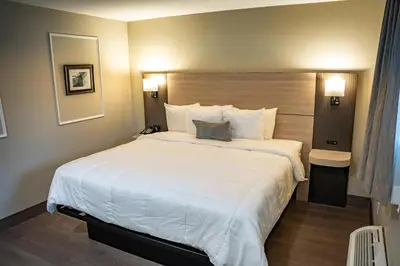 a large white bed in a hotel room at Whitman Motor Lodge in Huntington