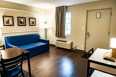 a living room with a blue couch and a table at Whitman Motor Lodge in Huntington
