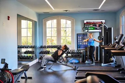 a man and a woman in a gym with weights at Mirbeau Inn & Spa, Rhinebeck in Rhinebeck