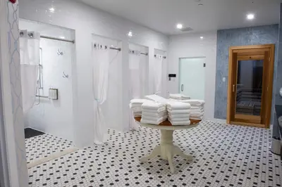 a bathroom with a shower and a table with towels at Mirbeau Inn & Spa, Rhinebeck in Rhinebeck