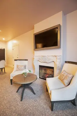 a living room with a fireplace and a tv at Mirbeau Inn & Spa, Rhinebeck in Rhinebeck