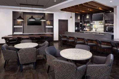 a restaurant with tables and chairs and a bar at Hyatt Place Poughkeepsie - Hudson Valley in Poughkeepsie
