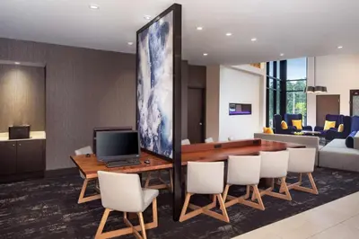 a conference room with a table with chairs and a television at Hyatt Place Poughkeepsie - Hudson Valley in Poughkeepsie