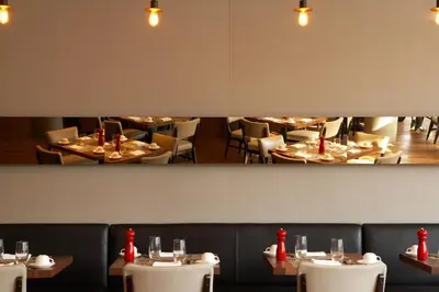 a dining room with white tables and chairs at The Study at Yale, Study Hotels in New Haven