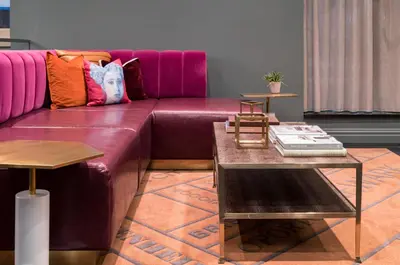 a living room with a purple couch and a table at TRYP by Wyndham Newark Downtown in Newark