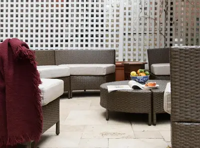 a patio with wicker chairs and a table with a bowl of fruit at TOWNHOUSE 222 in New York