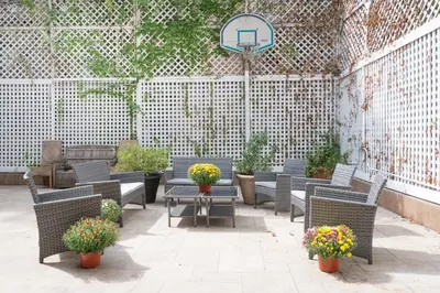 an outdoor patio with chairs and tables and flowers at TOWNHOUSE 222 in New York