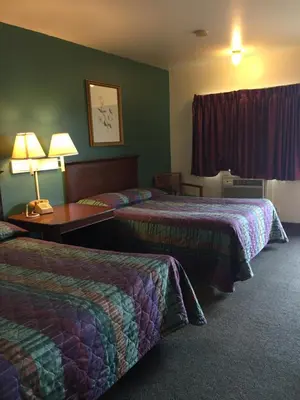 a hotel room with two beds and a table with lamps at Hudson Plaza Motel Bayonne Jersey City in Jersey City