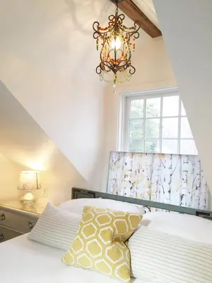 a bedroom with a bed with a chandelier and a window at The Connecticut River Valley Inn Hartford South/Glastonbury in Glastonbury