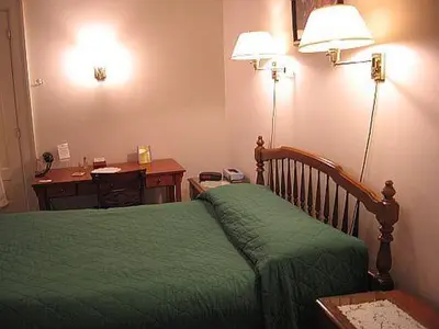 a bedroom with a green bed with a desk and a desk at Olde Judge Mansion B&B in Troy