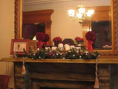 a mantel with christmas decorations and a mirror at Olde Judge Mansion B&B in Troy